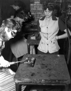 Women defense workers studying aircraft inspection