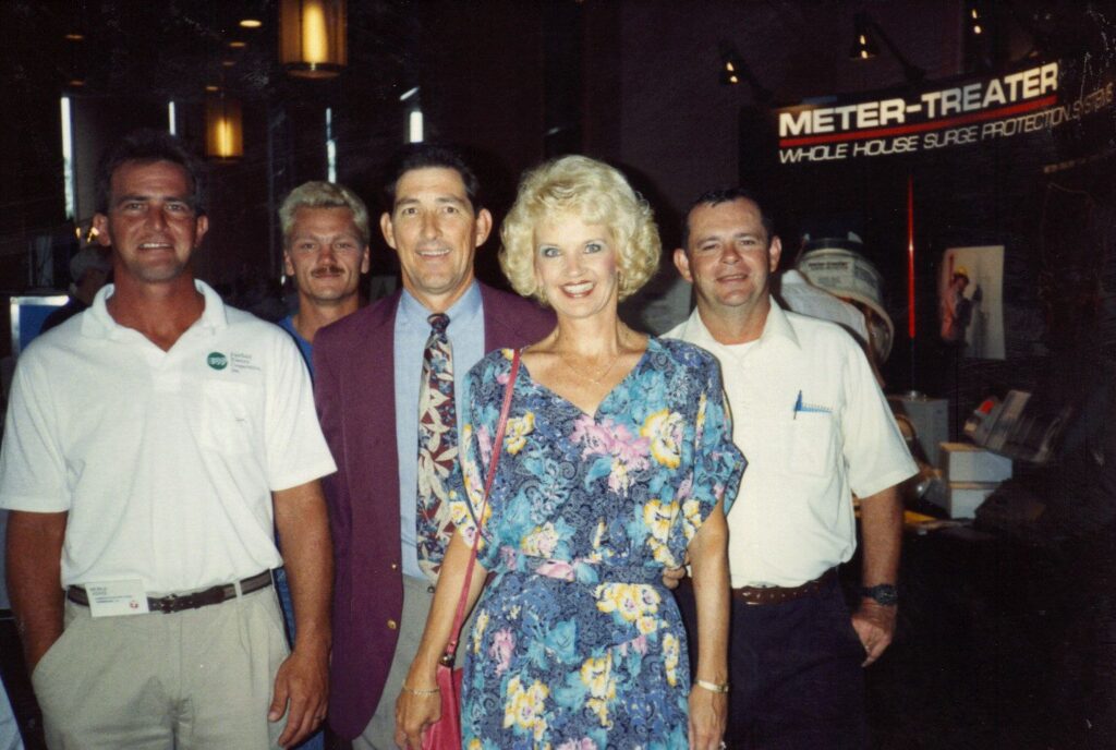 A photo of several attendees at the 1991 Meter School, in front of an exhibitor booth