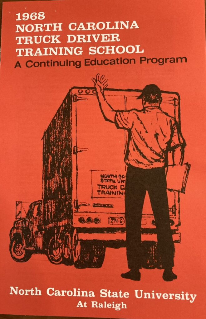 The 1968 cover of the Truck Driving School — depicting a monocrhome drawing of a man directing a truck in the process of backing up, set against a bold red background