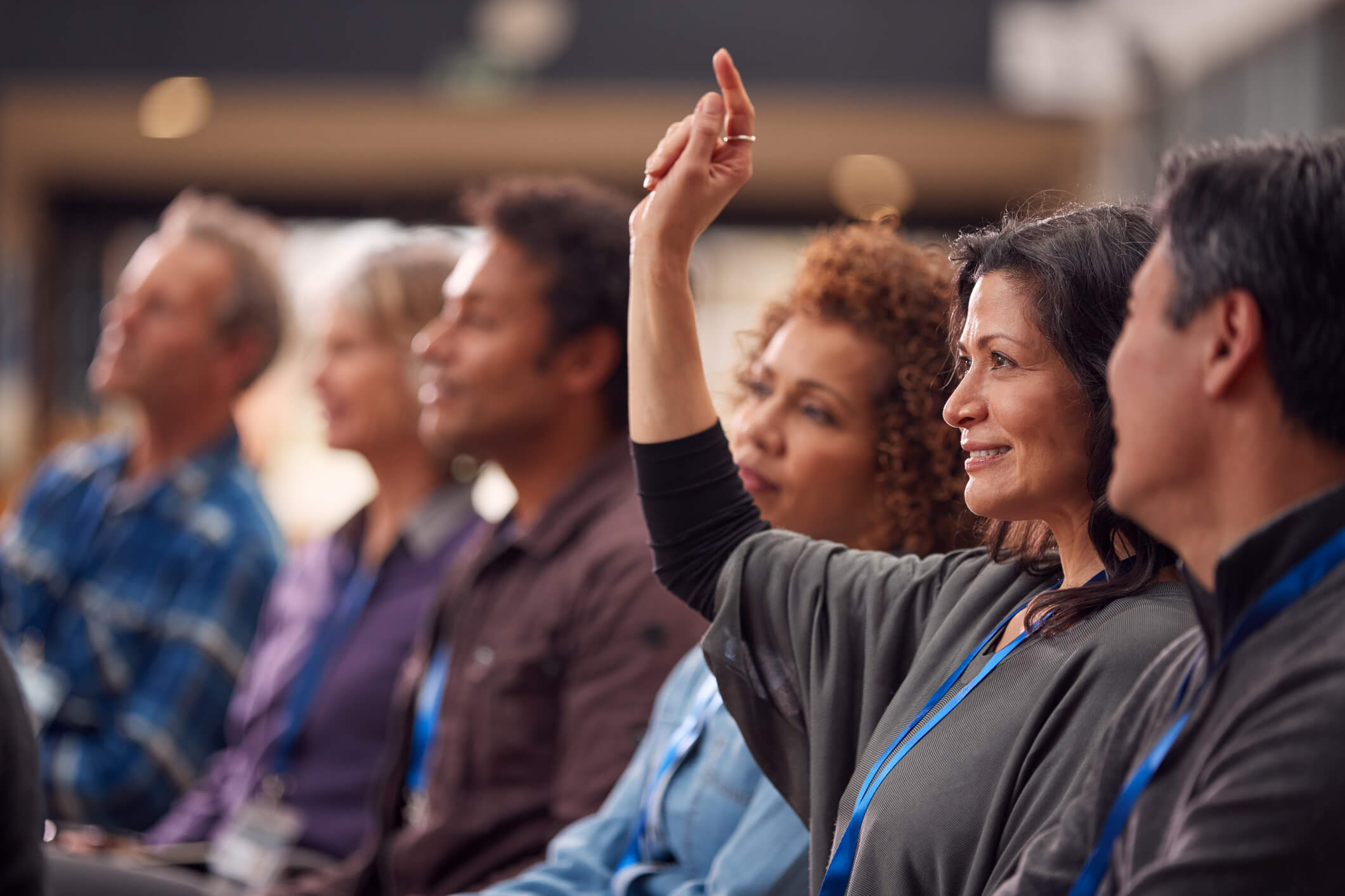 woman raising her hand in a classroom full of other adult learners