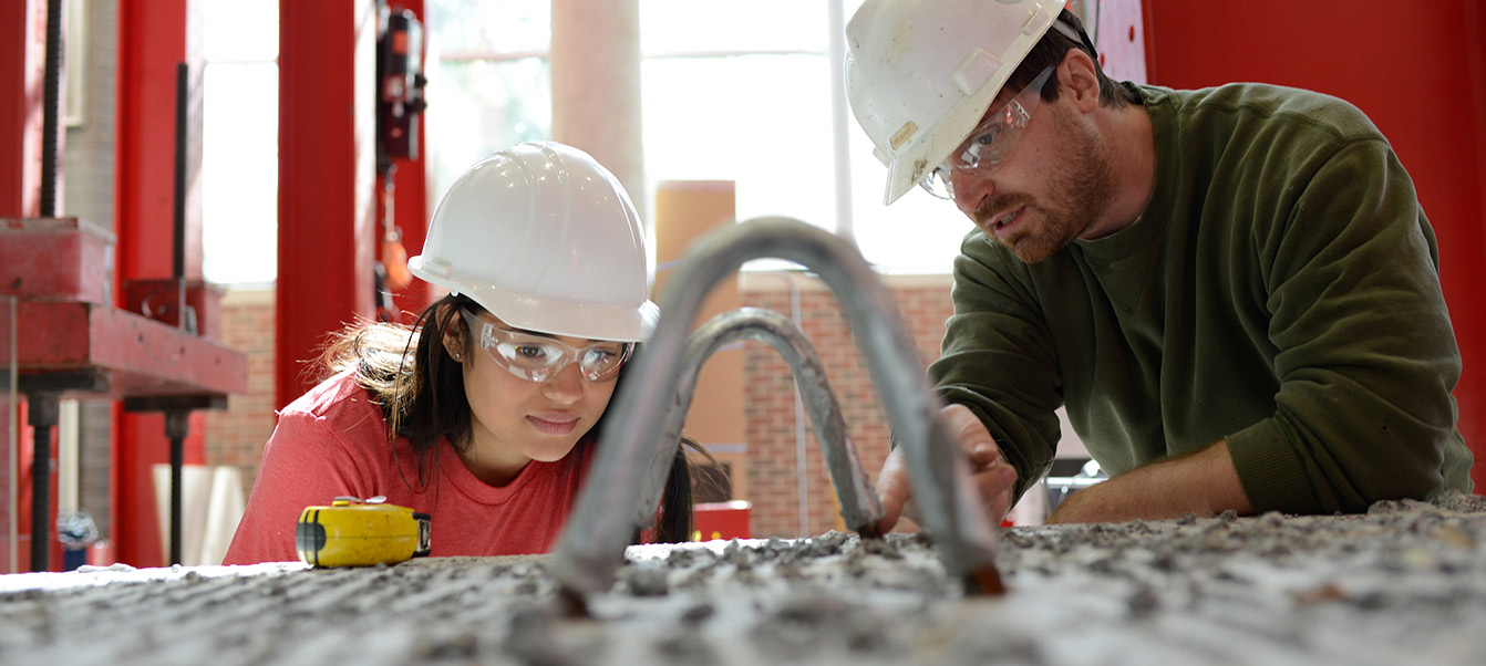 Student in the constructed facilities lab at NCSU with faculty member studying rebar and concrete durability.