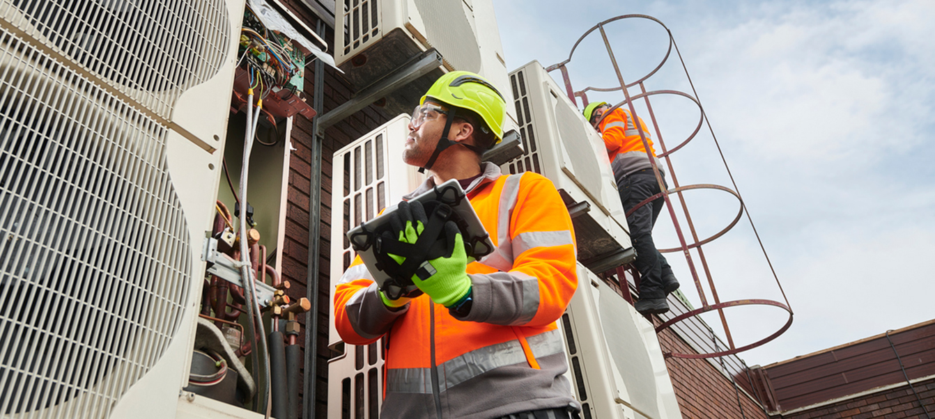 HVAC engineers on building rooftop conducting routine maintenance.