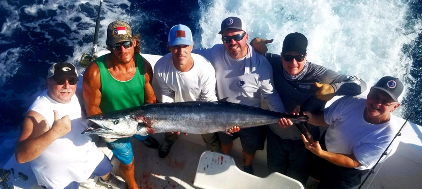 Participants at the Sport Fishing School holding a king mackerel or kingfish.