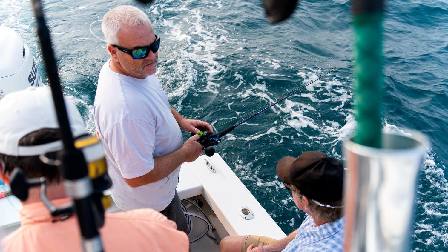 Sport Fishing School - June 2025 - man casting a rod while speaking to another man